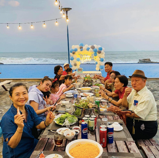 Family enjoying a beachfront BBQ Family enjoying a beachfront BBQ